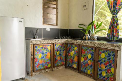 a kitchen with a counter with colorful tiles on it at Ecolodge el Arca Bahia Solano in Bahía Solano