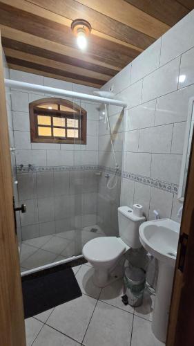 a bathroom with a toilet and a sink at Casa Três Amores in Búzios