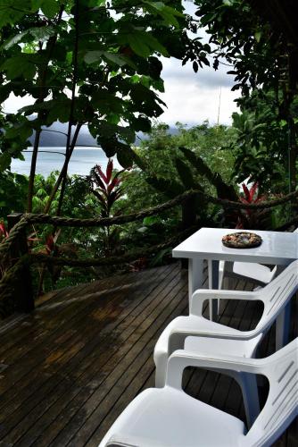 a white table and two white chairs on a deck at Ecolodge el Arca Bahia Solano in Bahía Solano