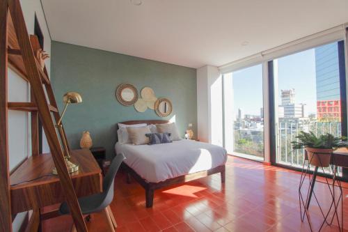 a bedroom with a bed and a large window at Tribu Chapultepec 67 in Guadalajara