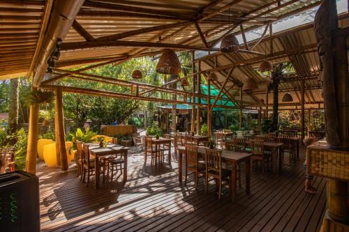 a restaurant with wooden tables and chairs on a wooden deck at Pousada Treze Luas in Ilha do Mel