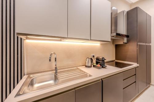 a kitchen with a stainless steel sink and white cabinets at The Bliss Apartments in Genova
