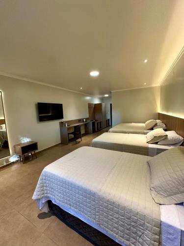 a hotel room with two beds and a flat screen tv at Parque Hotel Manantial in Hohenau