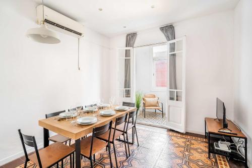 ein Esszimmer mit einem Holztisch und Stühlen in der Unterkunft Sagrada Familia- Emblematic and Charming Catalan Home in Barcelona