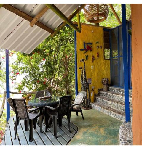 a patio with a table and chairs on a house at Ecolodge el Arca Bahia Solano in Bahía Solano