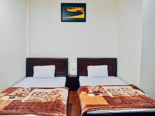 two beds sitting next to each other in a room at Huỳnh Gia Bảo Hotel in Bao Loc