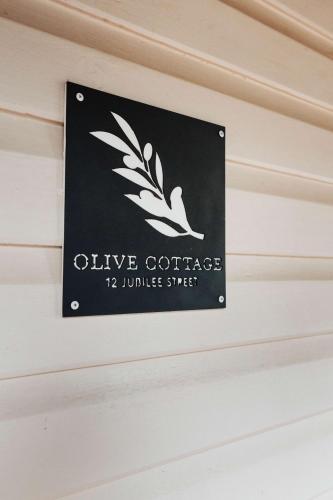 a sign that reads olive coffees juluitous stress at Olive Cottage - CBD Location, Pet friendly in Dubbo