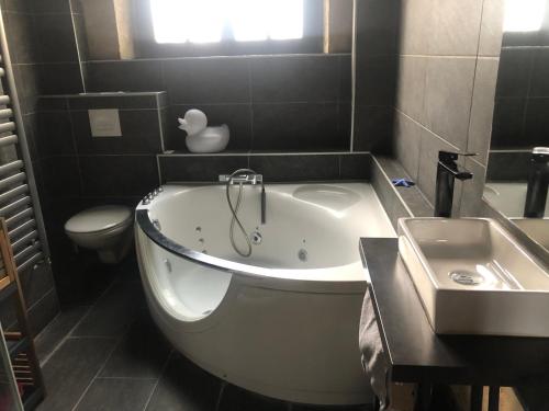 une salle de bain avec une baignoire, un lavabo et des toilettes dans l'établissement Jardin Abbatiale, à Rouen