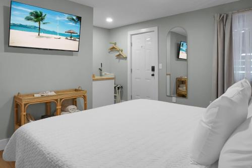 a bedroom with a white bed and a picture of a beach at Carolina Beach Motel in Carolina Beach