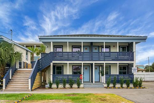a large house with a blue roof and stairs at Carolina Beach Motel in Carolina Beach