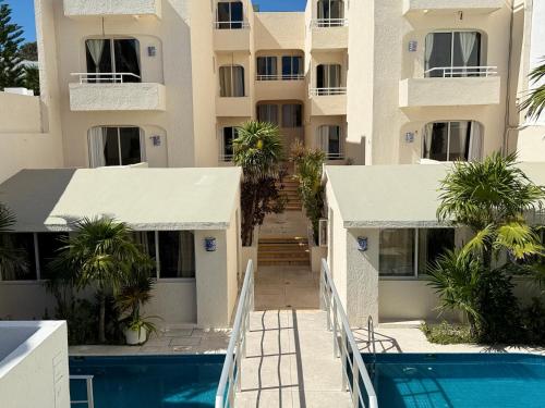 an external view of a building with a swimming pool at Luciana Hotel & Beach Club in Playa del Carmen