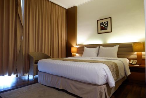 a hotel room with a large bed and a desk at Point C Hotel in Bandung