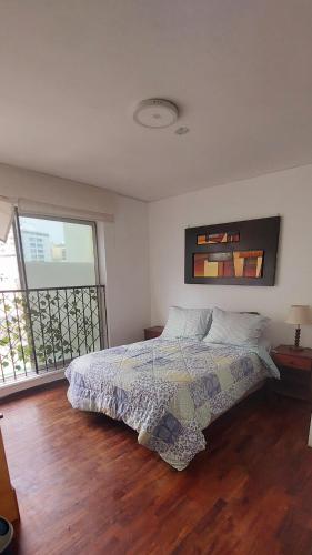 una camera da letto con un letto e una grande finestra di Habitaciones en Miraflores - Departamento compartido Maka's Home a Lima