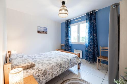 une chambre avec un lit aux murs bleus et une fenêtre dans l'établissement Charming Navarrosse House, à Biscarrosse