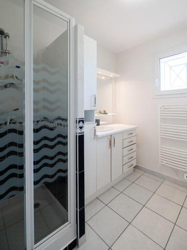 une salle de bain blanche avec une douche et un lavabo dans l'établissement Charming Navarrosse House, à Biscarrosse
