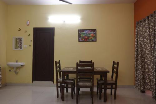 a dining room with a table and chairs and a sink at Lalitha Residency in Secunderabad