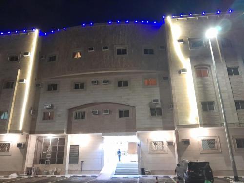 a building with a person walking in front of it at night at أحد 2 in Al Madinah