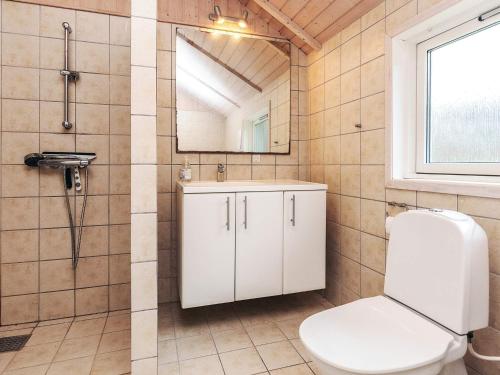 a bathroom with a toilet and a sink and a mirror at 6 person holiday home in Højby-By Traum in Højby