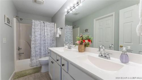 a white bathroom with a sink and a toilet at Gourgeous lake views, amazing susets, on main channel in Lake Ozark