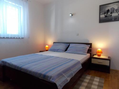 a bedroom with a bed and two lamps on tables at Apartment Markle in Banjol