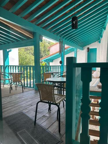 a wooden deck with chairs and a blue pergola at HACIENDA SHAKTIPAT in Finestret