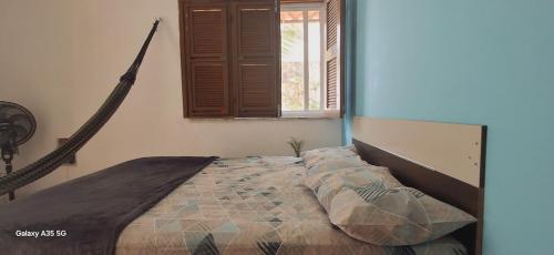 a large bed in a bedroom with a window at Casa bougainville in Caucaia