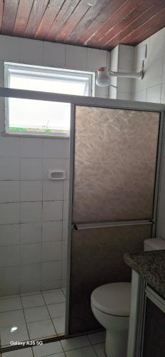 a bathroom with a shower with a toilet and a window at Casa bougainville in Caucaia