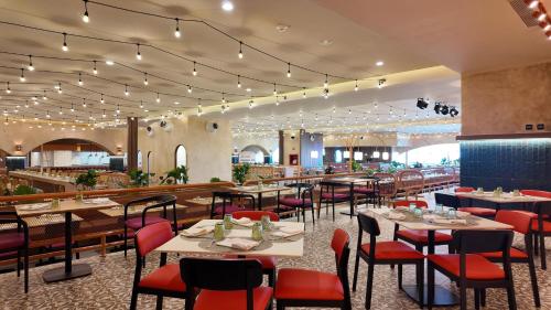 a restaurant with tables and chairs and a bar at Grand Sirenis Riviera Maya Resort & Spa All Inclusive in Akumal