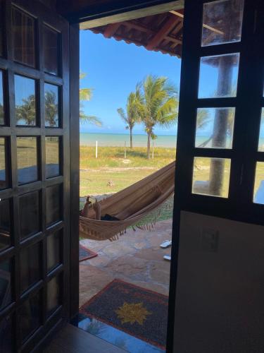 a room with a view of the beach and a hammock at Bangalô Mar & Sol in Alcobaça