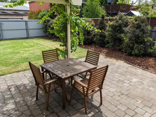 a wooden table and chairs on a patio at Heritage Chic in Central Albury in Albury