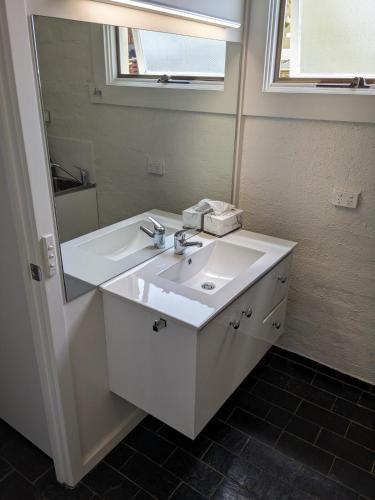 a bathroom with a white sink and a mirror at Heritage Chic in Central Albury in Albury