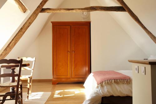 a bedroom with a wooden cabinet in a attic at Maison Saint-Martin in Calvignac