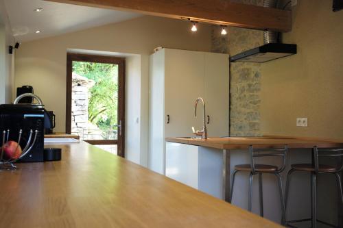 - une cuisine avec un comptoir et des tabourets dans l'établissement Maison Saint-Martin, à Calvignac