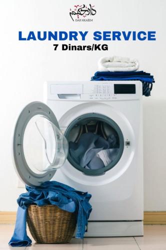 a washing machine with a laundry service pharmacy sign at Dar Hkaïem in Hammam Sousse