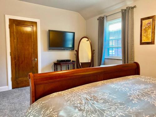 a bedroom with a bed and a tv and a mirror at Contemporary and modern, furnished 2 BR apartments, filled with desirable amenities in Toledo
