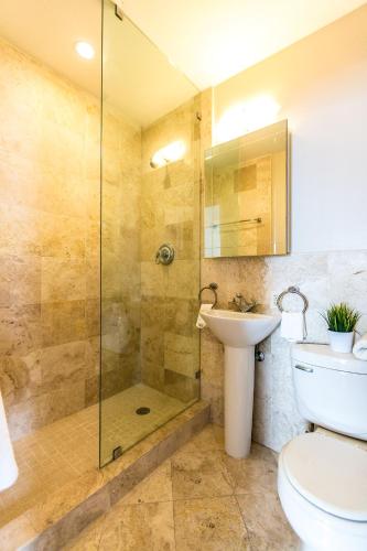 a bathroom with a shower and a toilet and a sink at Hudson Apartments in Miami Beach
