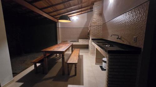 een keuken met een houten tafel en een wastafel bij Casa Colonial Cabore in Paraty