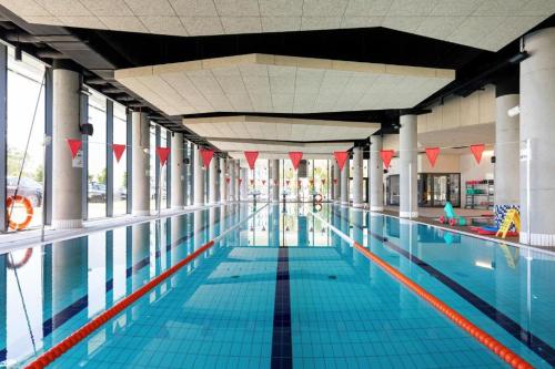 ein großer Pool mit roten Flaggen in einem Gebäude in der Unterkunft Apartament Art w hotelu Seaside in Kołobrzeg