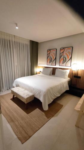 a bedroom with a large white bed and a bench at Contessa Suites in Lefkada Town