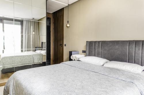 a bedroom with a large bed and a mirror at Luxury 1-Bedroom Apartment in Casablanca