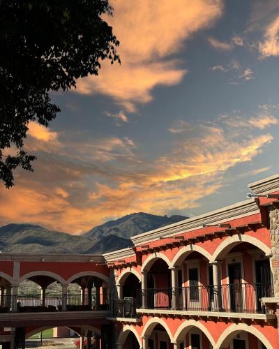a building with a balcony with mountains in the background at Hotel Real de los Alamos in Álamos