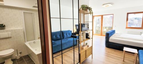 a living room with a blue couch and a bed at KOMM - Panoramablick - Balkon - Küche - Parkplatz in Suhl