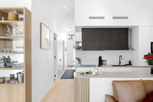 a kitchen with white counters and a counter top at Mod House Ocean Grove- Walk to the shops, cafes, beach and park! Brand new luxury apartment in gated complex in Ocean Grove
