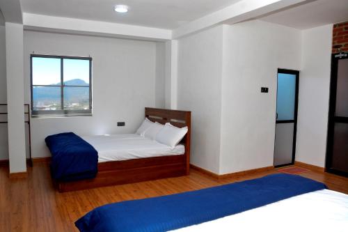 a bedroom with two beds and a window at High Cliff Villa in Nuwara Eliya