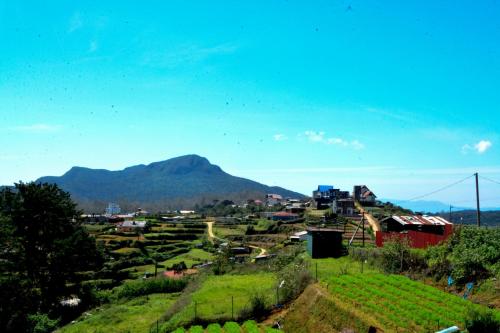 a small village with a mountain in the background at High Cliff Villa in Nuwara Eliya