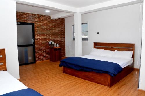 a bedroom with a bed and a brick wall at High Cliff Villa in Nuwara Eliya