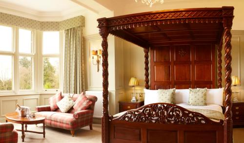 a bedroom with a large canopy bed and a chair at The Wrea Head Hall Country House Hotel & Restaurant in Scarborough