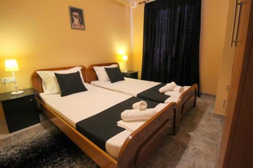 a bedroom with two beds with black and white pillows at Jericho rooms in Sarandë