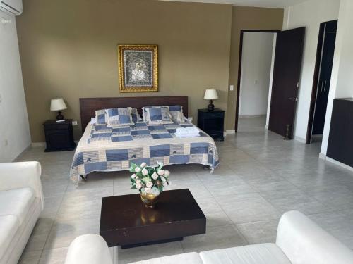 a large bedroom with a bed and a couch at CASARENA Casa campestre con apartamentos independientes en los llanos in Villavicencio