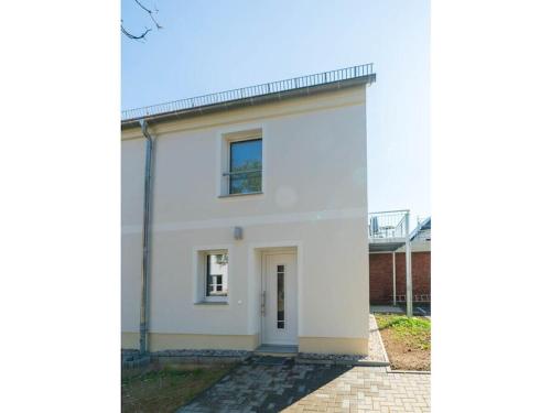 a white house with a window on the side at Holiday Apartment Haus Teichblick in Großzschepa